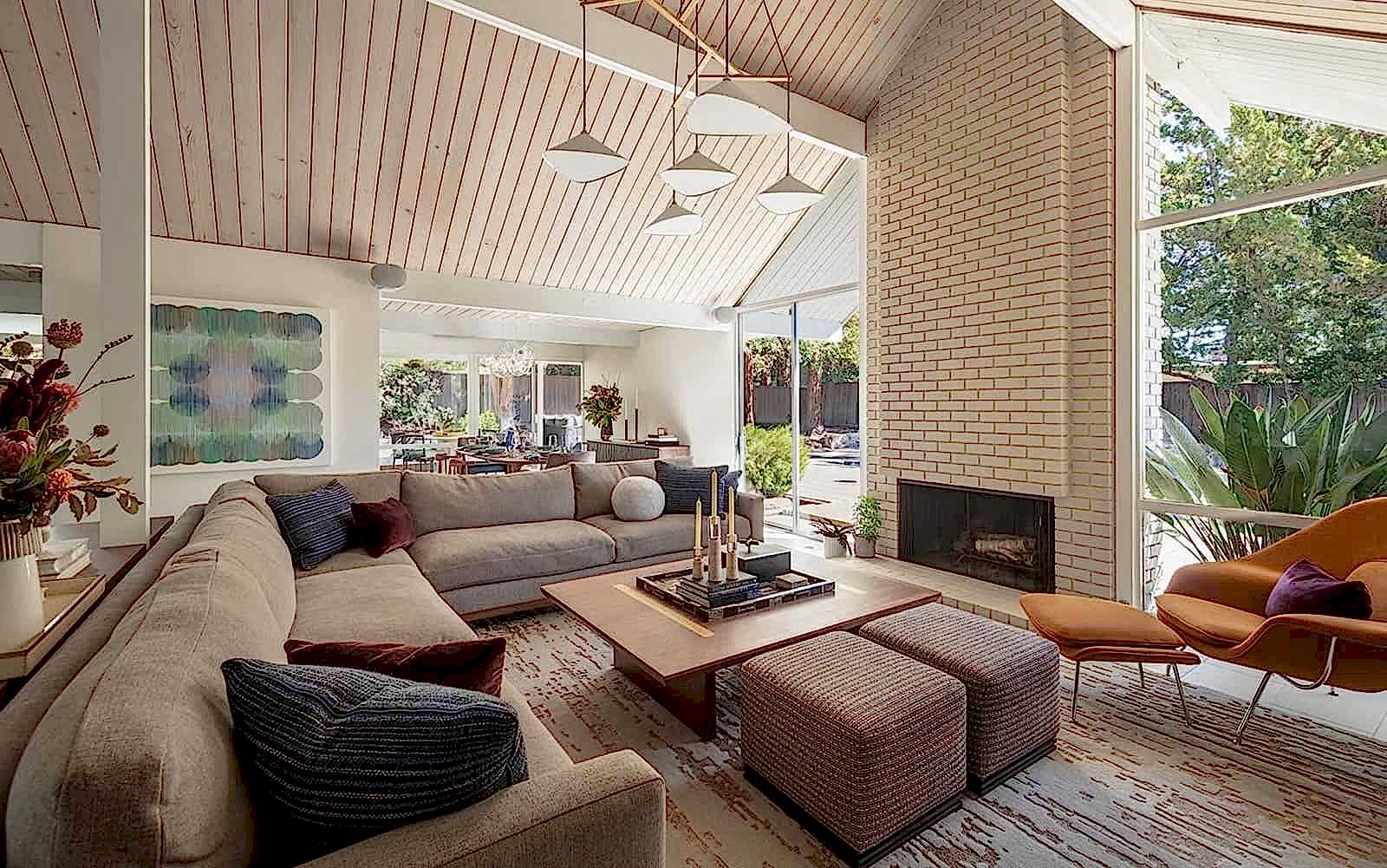 Stylish mid-century inspired living space combining clean lines, abundant natural light, and modern updates to suit a dynamic family lifestyle. This living room area features a Matt O’Reilly sectional, pendant light fixture by Two Enlighten, and artwork by Isabella Despojols via Stephanie Brietbard Fine Arts. This carefully curated space strikes a perfect balance between timeless elegance and contemporary functionality, ideal for sophisticated living in the San Francisco Bay Area.